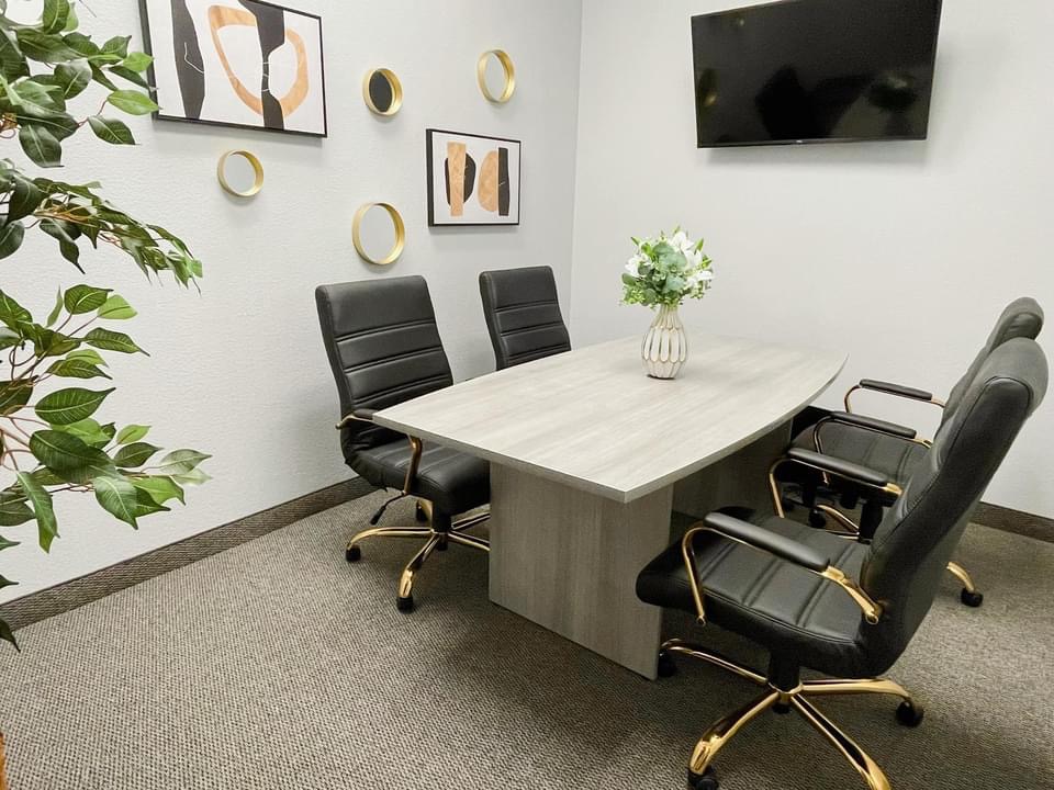 conference room with a table, 4 chairs, decor, and a TV